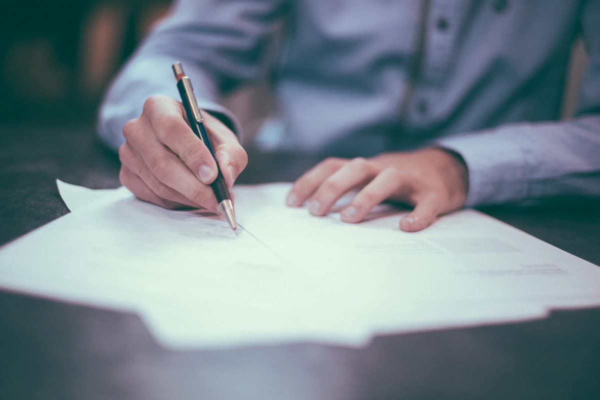 Reviewing and signing compliance documents at a desk