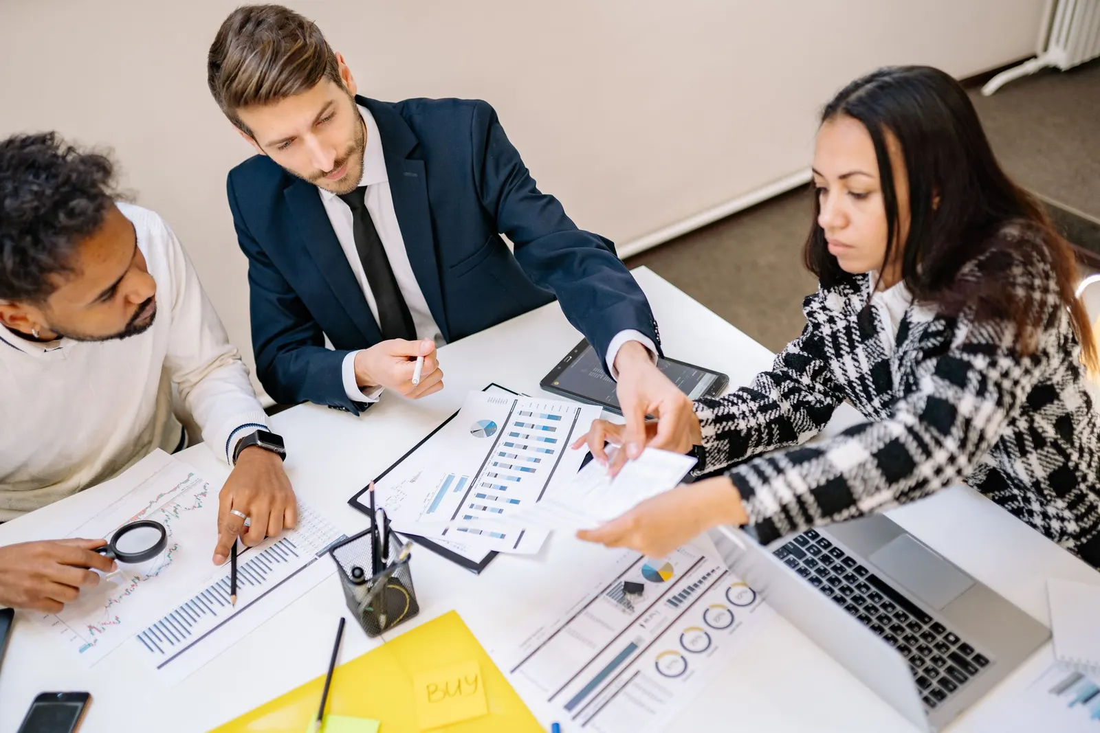 Advisors and clients reviewing charts and documents together at a meeting table
